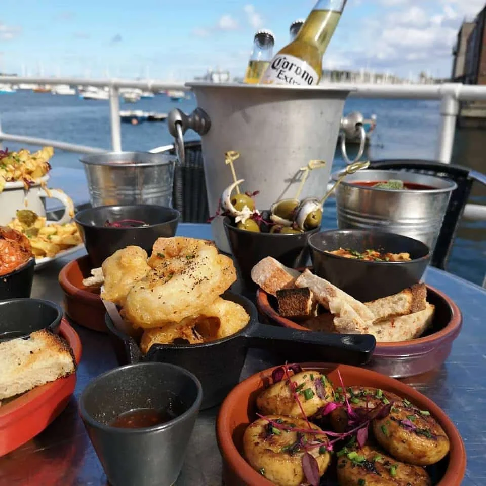 Small plates and drinks beside the harbour rail at The Pier Cafe