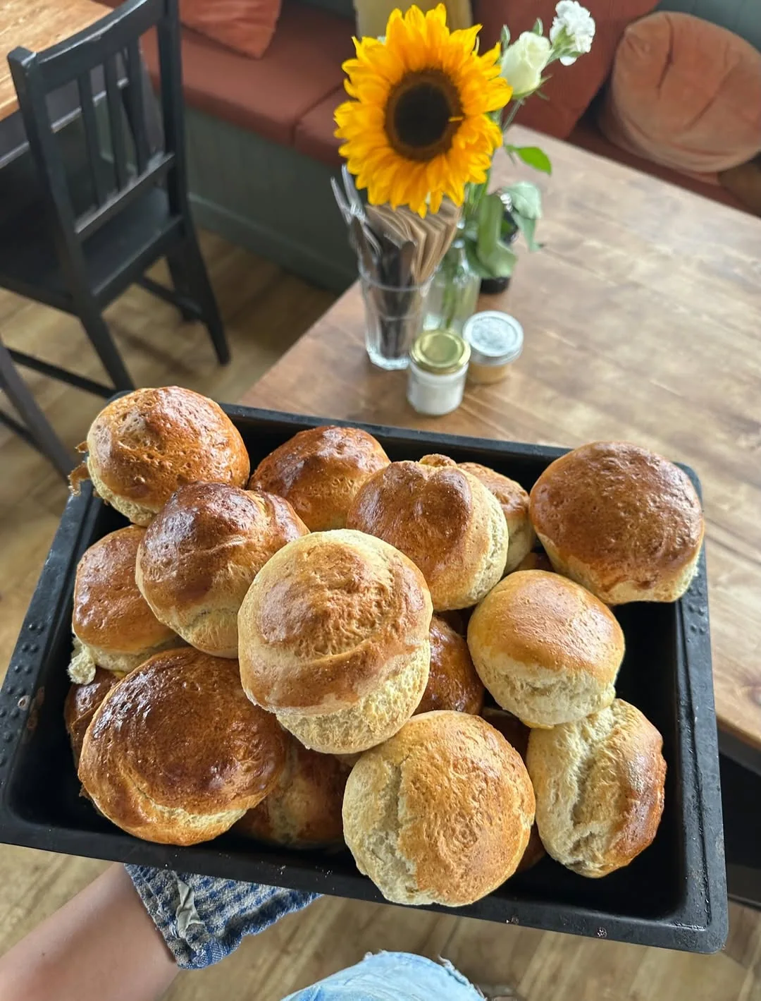 Freshly baked rolls held inside The Pier Cafe, with its green panelling and coral seating behind